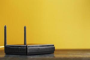 Black Wi-Fi router on a yellow background with free space. photo