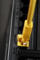 A yellow patch cord is inserted into the Wi-Fi port of the router to access the Internet. photo
