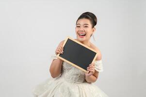 Young asian beautiful bride pose with blank blackboard in hand photo