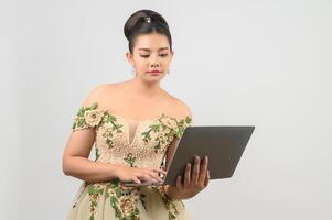 Young asian beautiful bride pose with laptop computer in hand photo