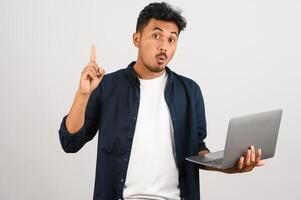 Portrait of a happy asian businessman working on laptop computer isolated over white background photo