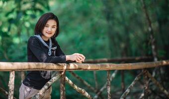 Protrait young woman looking beautiful nature while camping in forest photo