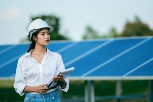 Asian young engineer female checking operation in solar farm photo