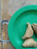 Tres delicioso empanadillas en un verde plato Listo a comer foto