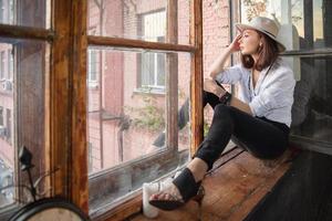 Cute lady is sitting near the window photo