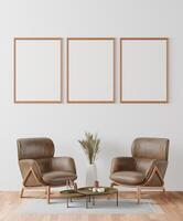 Picture frame attached to the wall, with chairs and vases placed on the table. photo