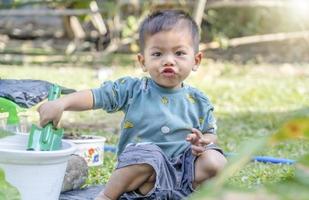 niño pequeño palea tierra en macetas para preparar plantas para plantar. niño pequeño cavando tierra para plantar para el pequeño ayudante de la madre. jardinería. pasatiempos en casa horticultura. concepto de actividades de ocio foto