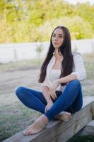 Pretty brunette dressed in a shirt and jeans photo