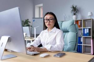 retrato de un joven hermosa asiático mujer en el oficina. foto