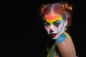 Charming young woman with a face painting clow photo