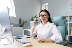 Allergy, feeling unwell at the workplace. A young Asian woman in the office looking at the camera photo