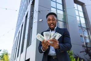 Happy successful African American businessman counts, waves, throws, show off photo