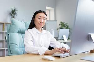 Close-up photo. Portrait of a young beautiful Asian woman secretary in the office photo