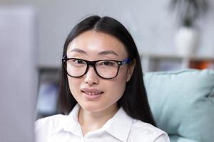 de cerca foto. retrato de un joven hermosa asiático mujer en el oficina foto