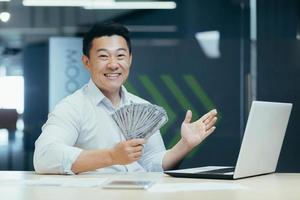 A happy Asian businessman concluded a profitable financial deal with clients and partners in office photo