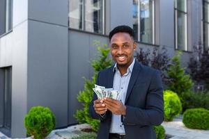 Happy successful African American businessman counts, waves, throws, show off photo