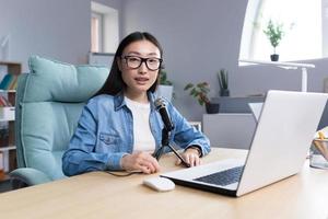 Portrait of young beautiful and successful Asian woman blogger, smiling and looking at camera photo