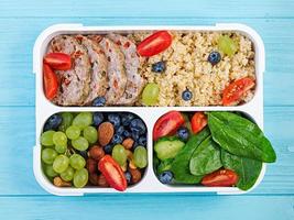 Lunch box  meatloaf, bulgur, nuts, tomato  and berry. Healthy fitness food. Take away. Lunchbox. Top view photo