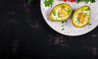 Avocado baked with egg and fresh salad. Vegetarian dish. Top view, overhead.  Ketogenic diet. Keto food photo