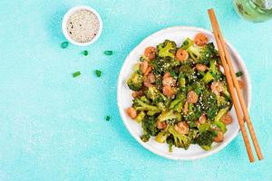 Stir fry shrimp with broccoli close up on a plate. Prawns and broccoli.  Top view, overhead photo