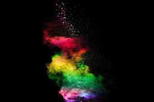 Explosion of colorful Holi powder on black background. Vibrant color dust particles textured background. photo