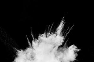 White powder explosion cloud against black background. White dust particles splash. photo