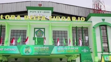 Sidoarjo, Indonesia - February 5 2023. Front angle of Gelora Delta Sidoarjo Main Stadium. Coincides with poster celebrating the centenary of Nahdlatul Ulama islamic organization video