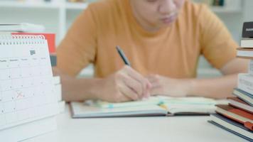 el estudiante asiático tiene ansiedad debido a los exámenes, los hombres se preparan para el examen y aprenden lecciones en la biblioteca. estrés, desesperación, prisa, malentendido lectura, desanimado, expectativa, conocimiento, cansado video