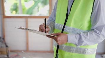 o inspetor ou engenheiro está inspecionando a construção e a garantia de qualidade da nova casa usando uma lista de verificação. engenheiros ou arquitetos ou empreiteiros trabalham para construir a casa antes de entregá-la ao proprietário