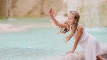 adorable peu fille près le Fontaine de Trevi dans Rome. content enfant prendre plaisir leur européen vacances dans Italie video