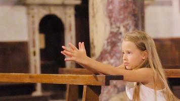 pequeño linda niña rezando en el Iglesia video