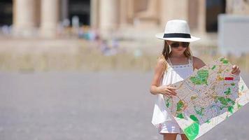 menina adorável com mapa turístico em st. Praça da Basílica de São Pedro, Itália. garoto toodler feliz aproveite as férias de férias italianas na europa. video