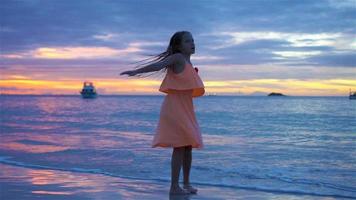 sihueta de menina dançando na praia ao pôr do sol. video