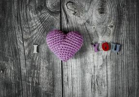 Knitted heart on gray wooden background photo