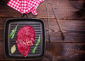 raw beef steak on a black quart pan photo