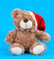 little cute brown teddy bear with in a red Christmas hat photo