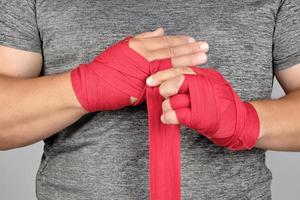 sportsmans hands wrapped in a red elastic sports bandage photo