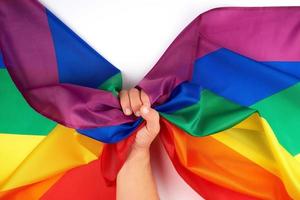 male hand holds a rainbow flag a symbol of the LGBT community photo