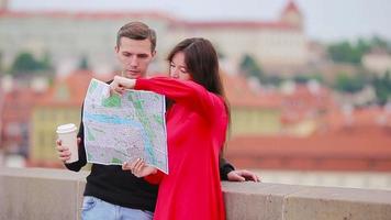 joven pareja de turistas viajando de vacaciones en europa sonriendo feliz. familia caucásica con mapa de la ciudad en busca de atracciones video