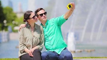 Young tourist friends traveling on holidays in Europe smiling happy. Caucasian couple with city map making selfie background of attractions video