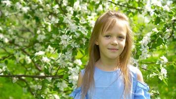 adorable petite fille dans un jardin de pommiers en fleurs le beau jour du printemps video