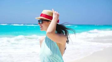 skön kvinna på sommar högtider leende Lycklig på vit strand. Lycklig flicka gående i sommar klänning. långsam rörelse video