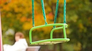 Closeup empty swing in autumn park outdoors video