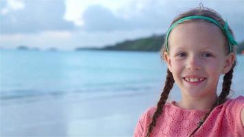 adorable niña haciendo selfie en playa blanca tropical. camara lenta