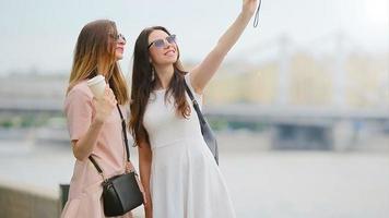 jovem lindo meninas tendo Diversão e fazer selfie. conceito do amizade e Diversão com Novo tendências e tecnologia. melhor amigos salvando a momento com seus amarelo Câmera video