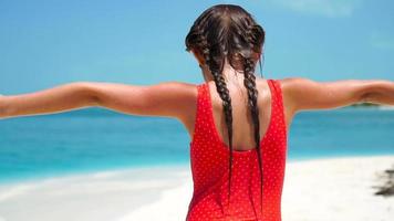 Adorable little girl at beach having a lot of fun on summer holidays. Funny girl in slow motion video