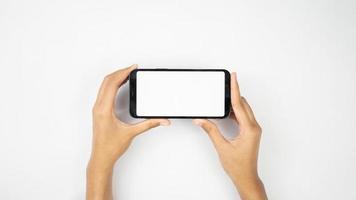 Two hands holding white blank smartphone horizontally photo