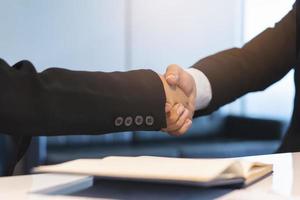 Two businessmen shaking hands after negotiation deal agree. photo