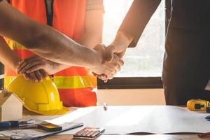 construcción trabajador y contratista. cliente sacudida manos con equipo constructor en renovación sitio. foto