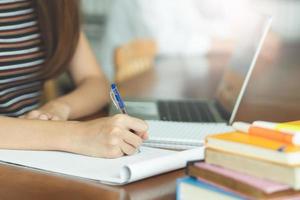female asian student studying and reading book in library photo